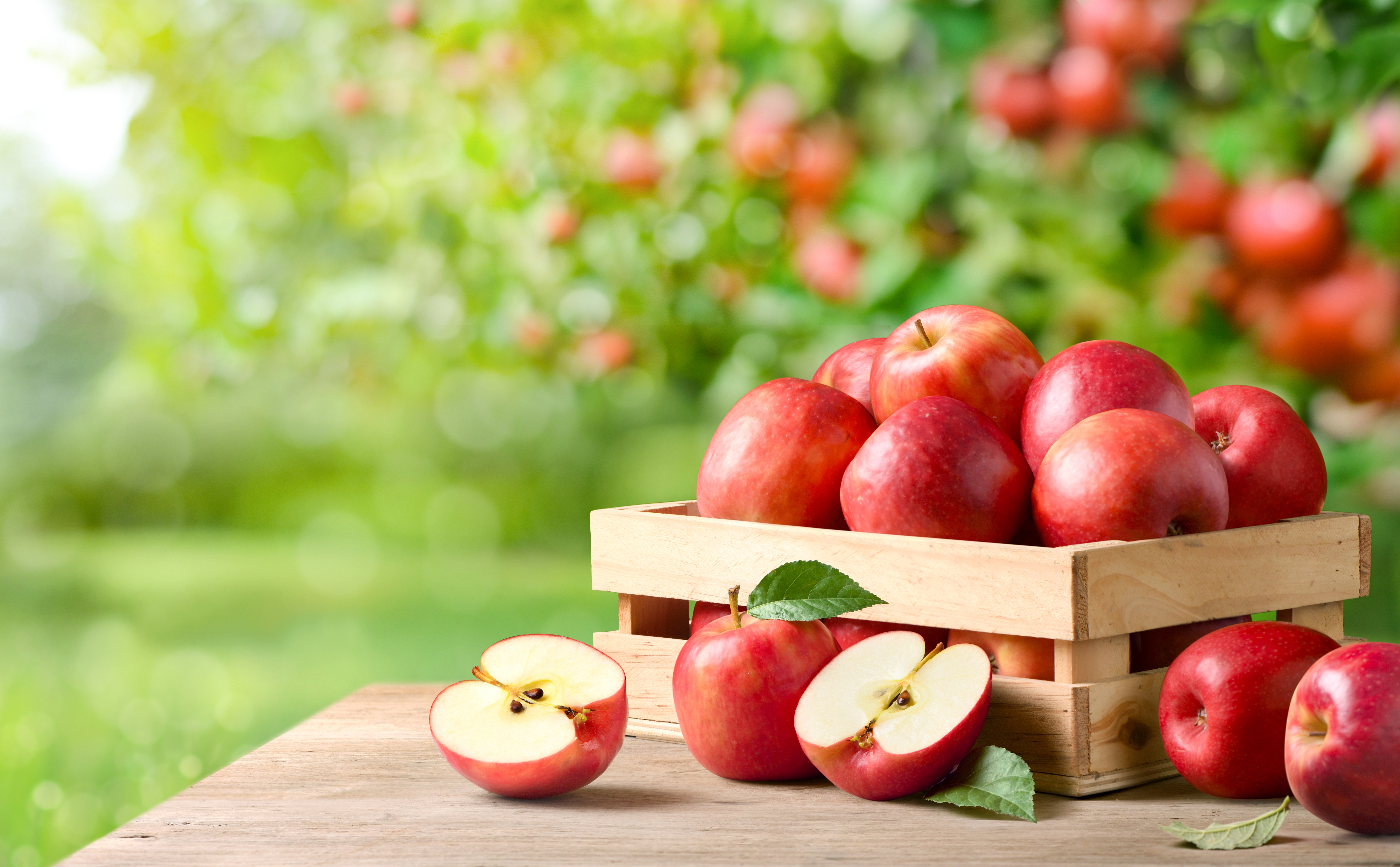 Fresh,Red,Apples,With,Cut,In,Half,On,Wooden,Table