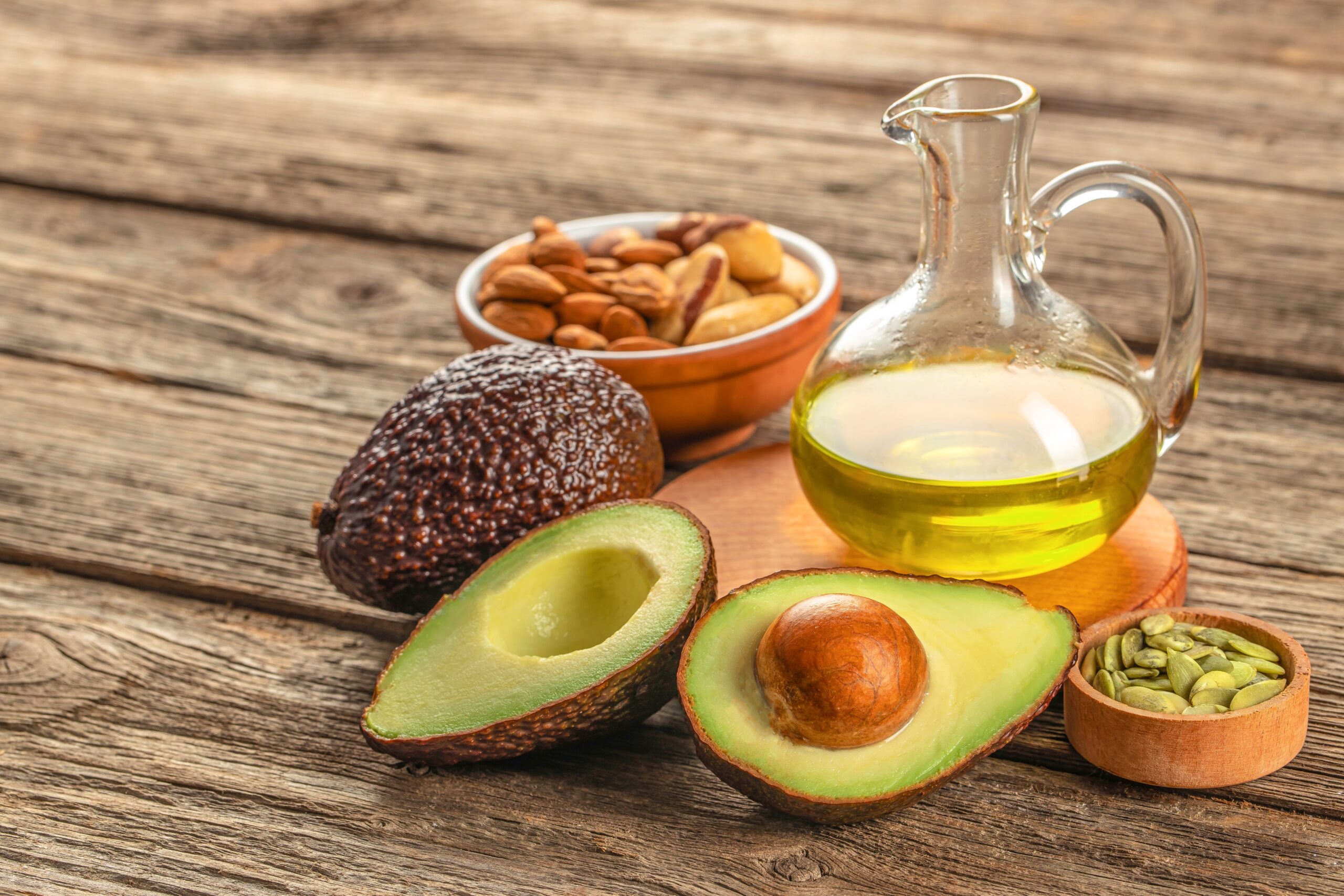 Healthy,Fat,Avocado,Oil,Nuts,On,A,Wooden,Background.,Top